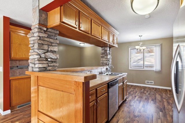 kitchen featuring visible vents, dark wood-type flooring, a sink, appliances with stainless steel finishes, and ornate columns