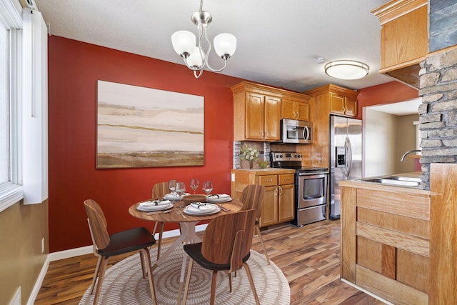 kitchen featuring light wood-type flooring, visible vents, a sink, appliances with stainless steel finishes, and baseboards