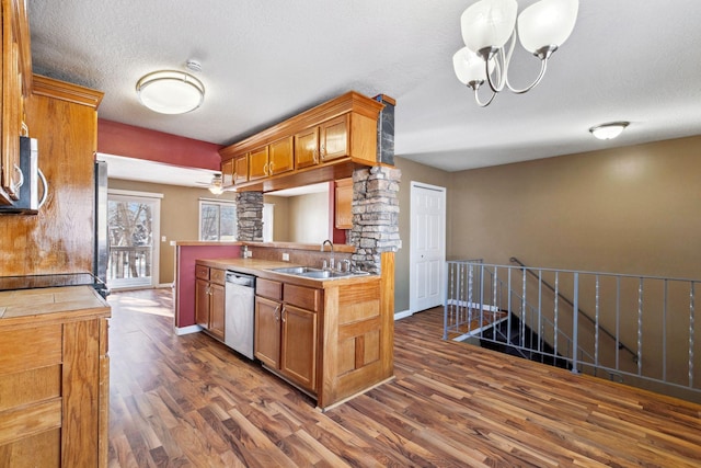 kitchen with dark wood finished floors, decorative columns, appliances with stainless steel finishes, a textured ceiling, and a sink