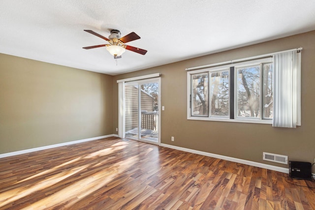 unfurnished room featuring visible vents, baseboards, ceiling fan, and wood finished floors