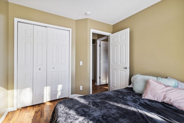 bedroom featuring a closet, baseboards, and wood finished floors