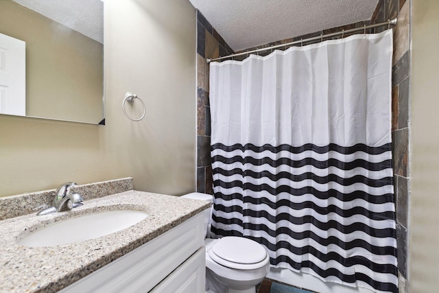 bathroom with vanity, curtained shower, toilet, and a textured ceiling