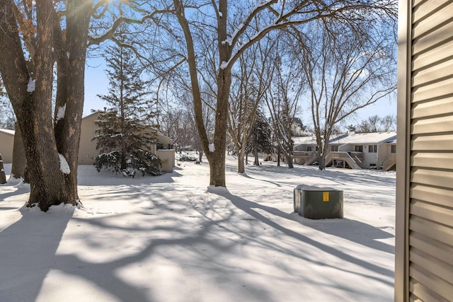 yard covered in snow with stairs and a residential view