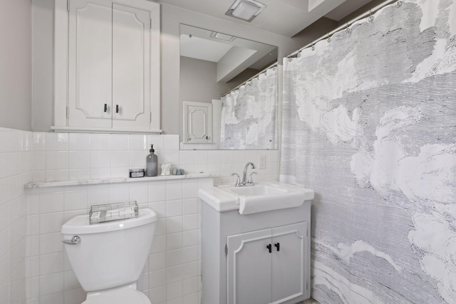 bathroom with vanity, tile walls, and toilet