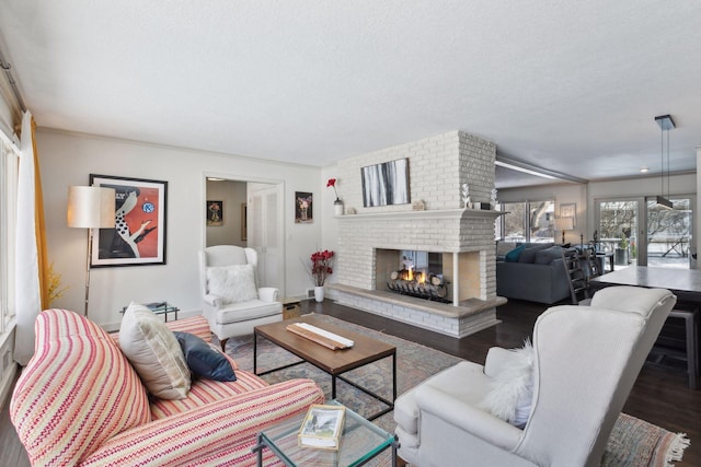 living room with dark hardwood / wood-style floors, a textured ceiling, and a fireplace