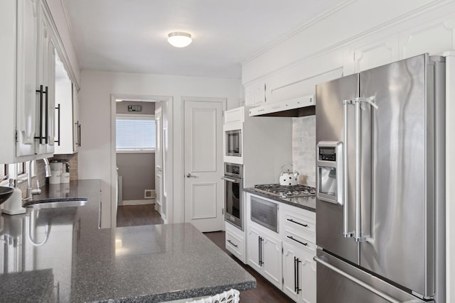 kitchen with backsplash, stainless steel appliances, sink, and white cabinets