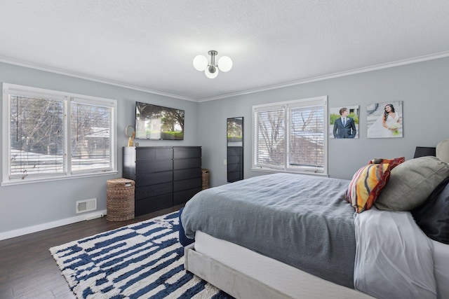 bedroom with ornamental molding, a textured ceiling, and dark hardwood / wood-style flooring