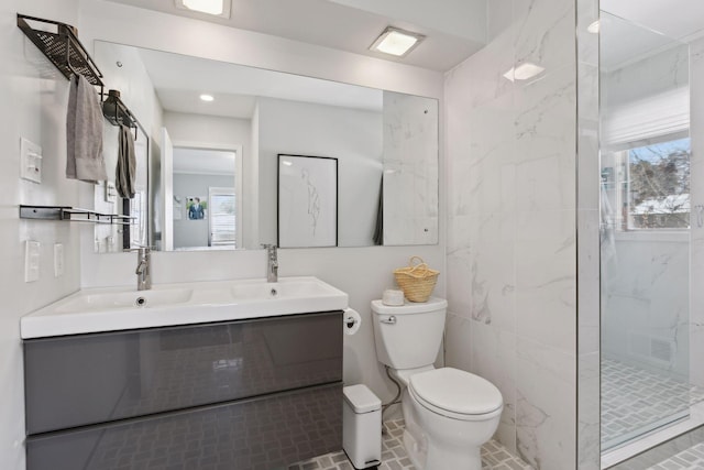 bathroom with vanity, a tile shower, and toilet