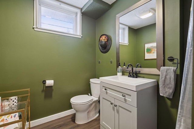 bathroom featuring vanity, wood-type flooring, a wealth of natural light, and toilet