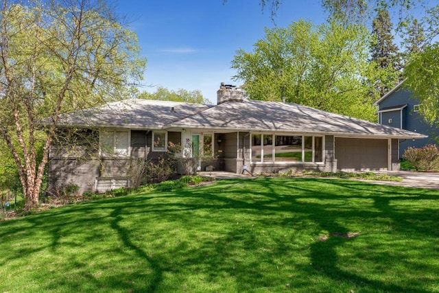 ranch-style home featuring a garage and a front lawn