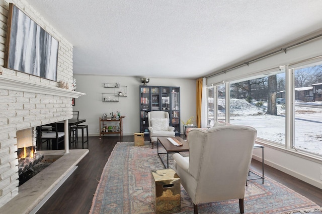 living room with a fireplace, dark hardwood / wood-style floors, and a textured ceiling