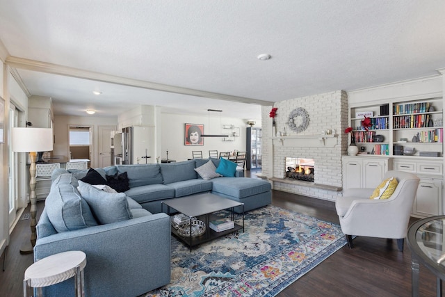 living room with a brick fireplace, dark hardwood / wood-style floors, and a textured ceiling