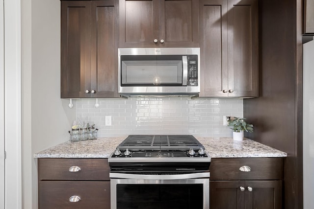 kitchen with light stone counters, decorative backsplash, stainless steel appliances, and dark brown cabinetry