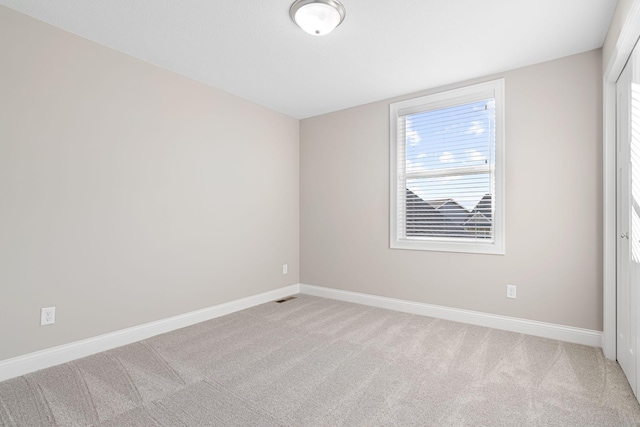 unfurnished room with light carpet