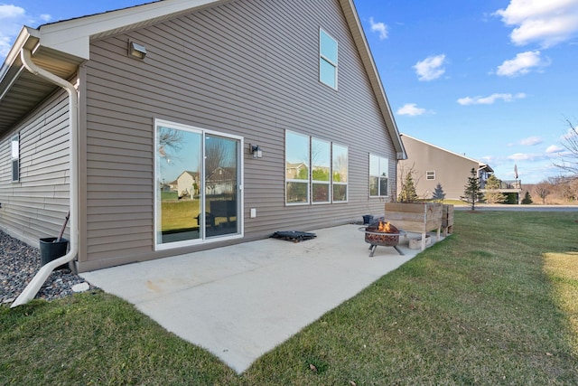 rear view of property with a lawn, a patio area, and a fire pit