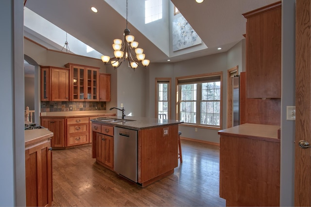 kitchen featuring pendant lighting, sink, appliances with stainless steel finishes, a kitchen island with sink, and hardwood / wood-style floors