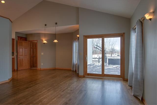 unfurnished living room featuring dark hardwood / wood-style flooring and high vaulted ceiling