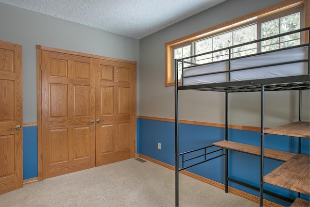 bedroom with a textured ceiling and carpet flooring