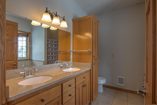 bathroom with tile patterned flooring, vanity, and toilet