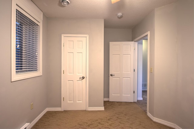 interior space featuring carpet floors and a textured ceiling