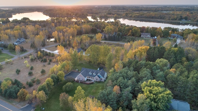 aerial view at dusk featuring a water view