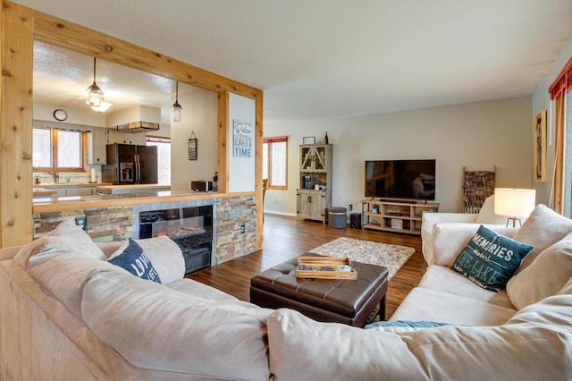 living room featuring sink, a fireplace, hardwood / wood-style floors, and a textured ceiling