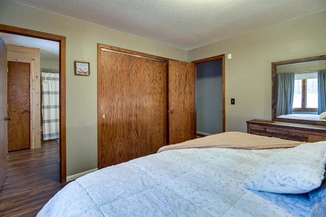 bedroom featuring a textured ceiling, dark hardwood / wood-style flooring, and a closet