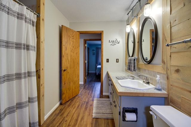 bathroom featuring wood-type flooring, a shower with shower curtain, vanity, and toilet