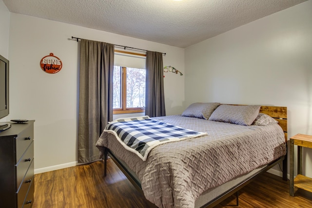 bedroom featuring dark hardwood / wood-style floors and a textured ceiling