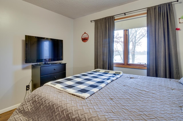 bedroom with wood-type flooring and a textured ceiling