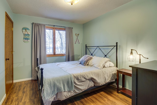 bedroom with dark wood-type flooring and a textured ceiling