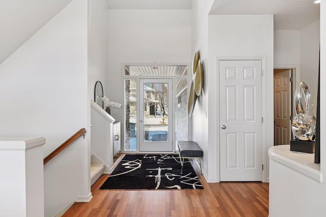 entryway featuring stairway, wood finished floors, and baseboards