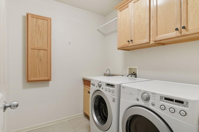 clothes washing area with washer and clothes dryer, a sink, cabinet space, light tile patterned floors, and baseboards