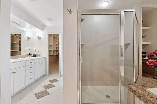 bathroom featuring a spacious closet, a shower stall, and vanity