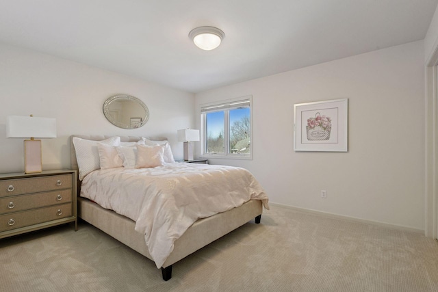 bedroom featuring light carpet and baseboards