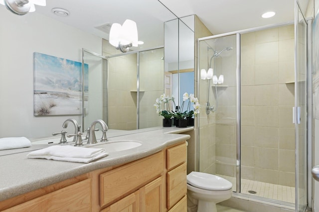 bathroom featuring a shower stall, toilet, and vanity