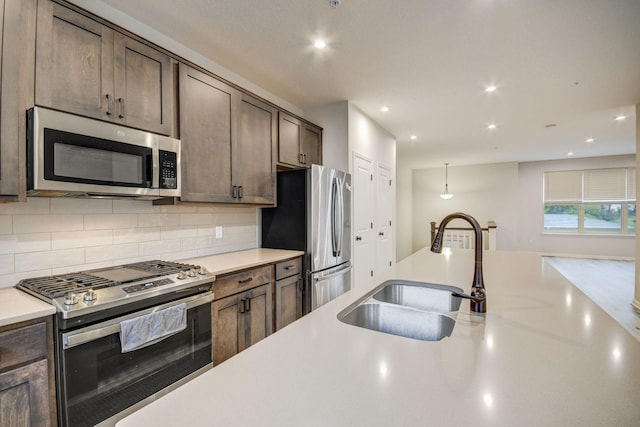 kitchen with sink, decorative backsplash, dark brown cabinets, and appliances with stainless steel finishes