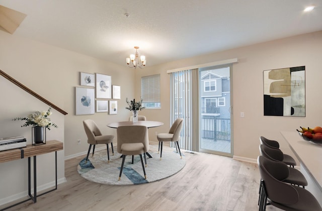 dining area with an inviting chandelier and light hardwood / wood-style floors