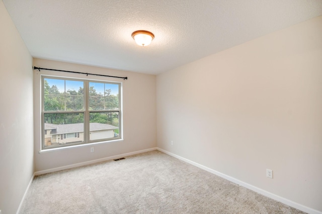 carpeted empty room featuring a textured ceiling