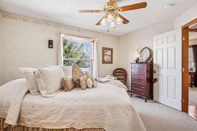 bedroom featuring a textured ceiling, light carpet, and ceiling fan