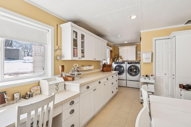 kitchen featuring white cabinetry, crown molding, separate washer and dryer, and light tile patterned floors