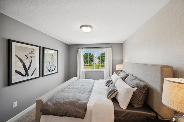 bedroom with carpet floors and a textured ceiling