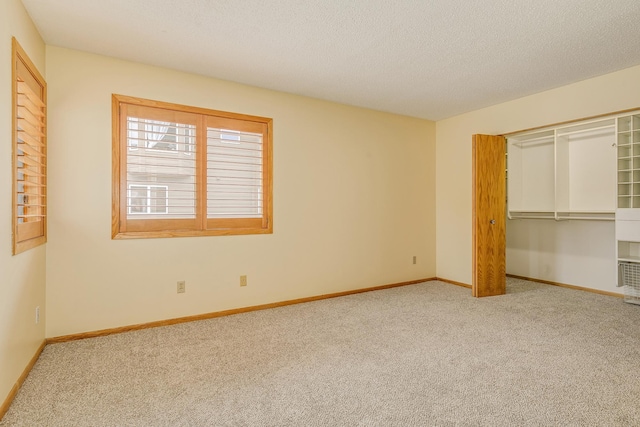 unfurnished bedroom with carpet, a textured ceiling, and a closet