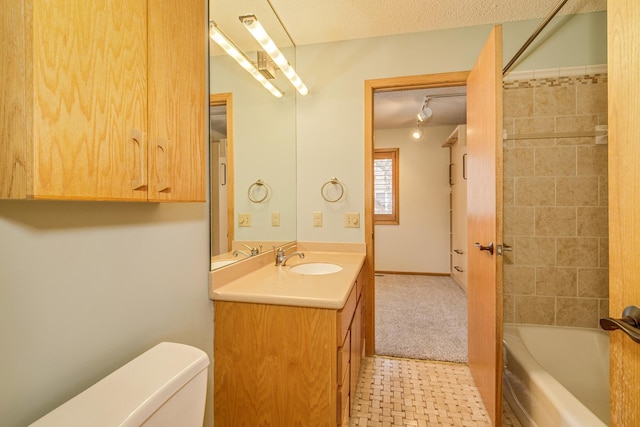 full bathroom featuring vanity, toilet, tiled shower / bath combo, and a textured ceiling