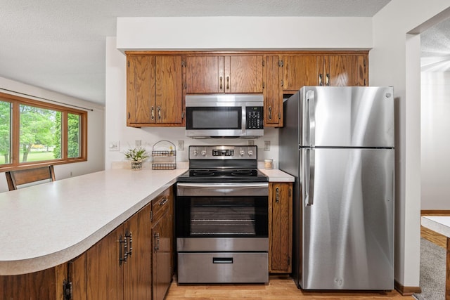 1541 2nd Ave SE, Cambridge, MN 55008 - kitchen featuring stainless steel appliances, brown cabinets, and light countertops
