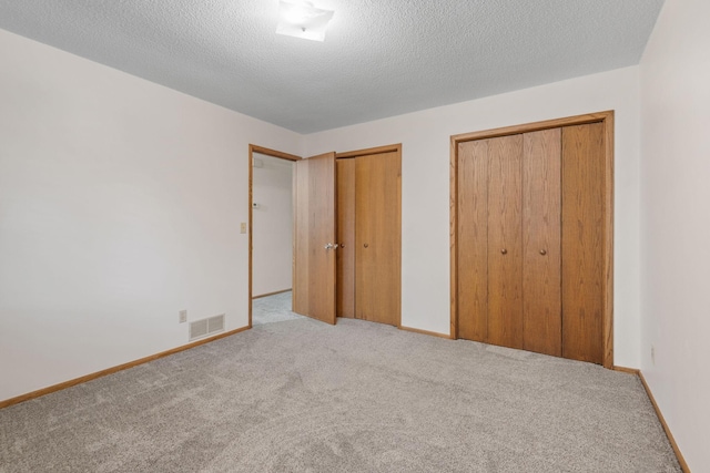 1541 2nd Ave SE, Cambridge, MN 55008 - unfurnished bedroom featuring two closets, carpet flooring, and a textured ceiling