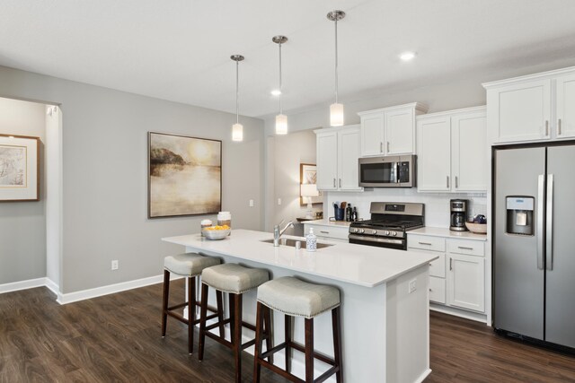 12450 Waterside Ct, Rogers, MN 55374 - kitchen with stainless steel appliances, a sink, dark wood-type flooring, an island with sink, and light countertops