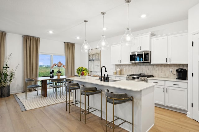9662 49th St NE, Saint Michael, MN 55376 - kitchen with stainless steel appliances, tasteful backsplash, an island with sink, light countertops, and a kitchen bar