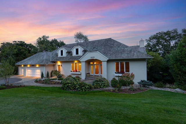 view of front of home with a garage and a lawn