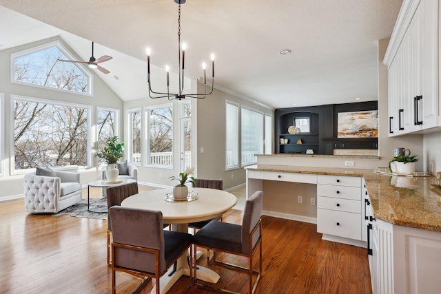 dining area featuring hardwood / wood-style flooring, ceiling fan, high vaulted ceiling, and a wealth of natural light